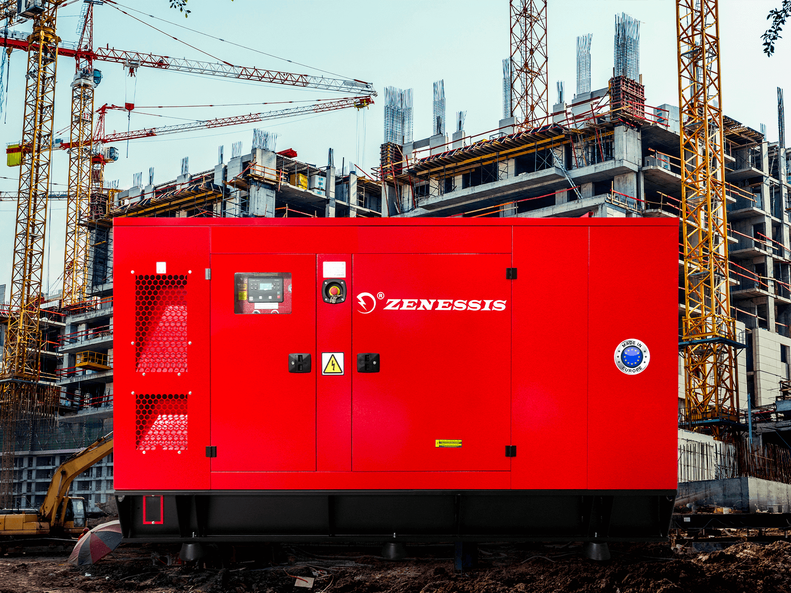Generator diesel ZENESSIS de mare putere instalat pe un șantier de construcții, în fața unei clădiri aflate în lucru, cu macarale în fundal.